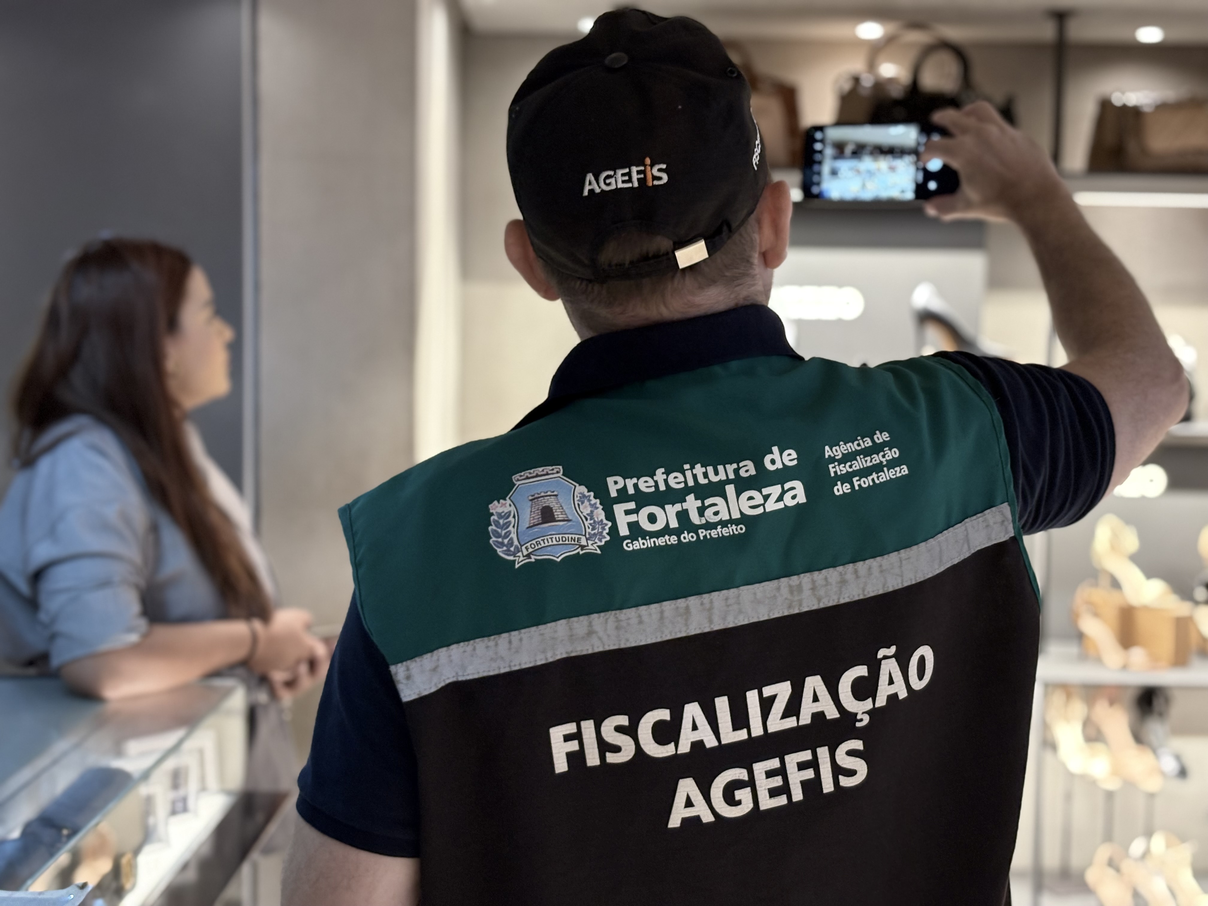 fiscal da agefis de costas dentro de uma loja
